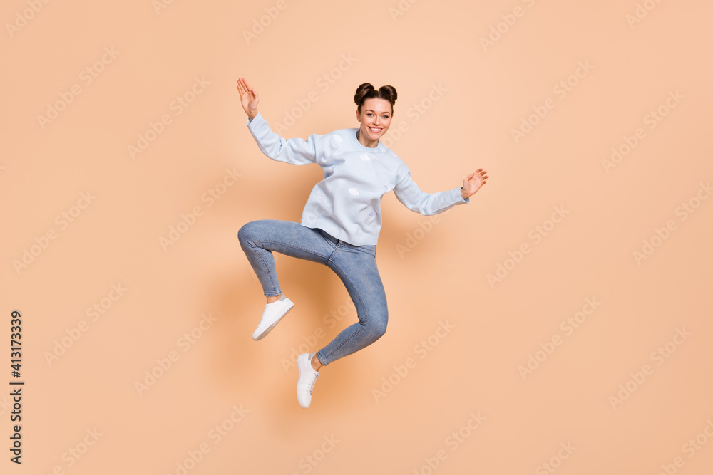Full size photo of optimistic nice brunette lady jump dance wear blue sweater jeans sneakers isolated on beige background