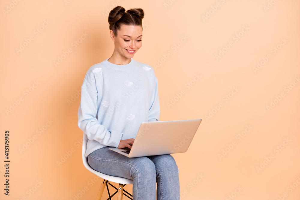 Photo of optimistic brunette lady sit write laptop wear sweater jeans isolated on pastel beige color background Photo of optimistic brunette lady sit write laptop wear sweater jeans isolated on pastel beige color background