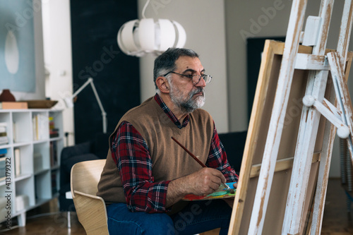 senior man painting the picture at his home