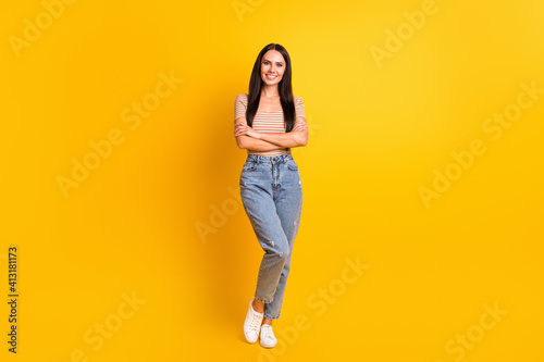 Full length body size photo of female student crossed hands smiling wearing casual clothes isolated on vivid yellow color background