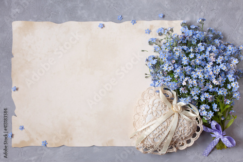 Fototapeta Naklejka Na Ścianę i Meble -   Bouquet of forget me nots flowers and congratulatory paper, letters, heart