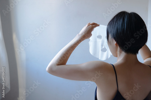 フェイスマスクをする女性の後ろ姿