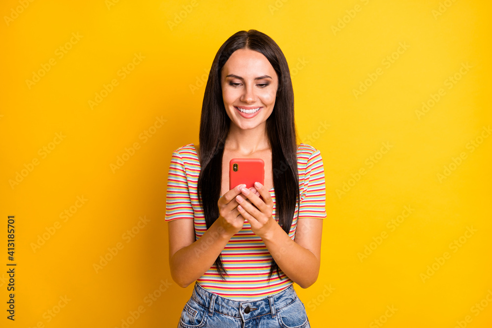 Photo portrait of young brunette using app on smartphone browsing internet isolated on vibrant yellow color background