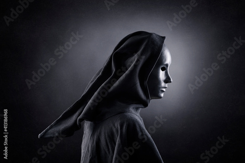 фотографія Scary figure with hooded cloak in the dark
