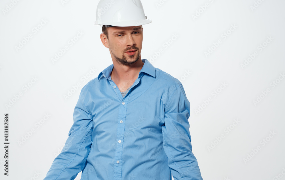 Emotional architect builder in a white helmet and in a blue shirt on an isolated background Emotional architect builder in a white helmet and in a blue shirt on an isolated background