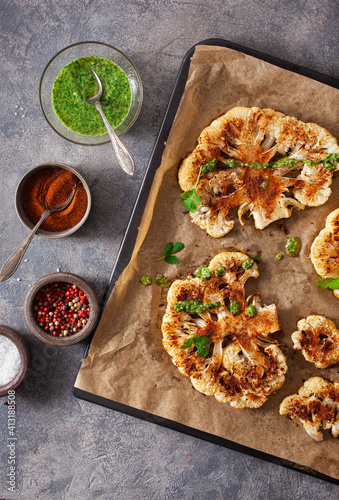 cauliflower steaks with herb and spice on baking tray. plant based meat substitute