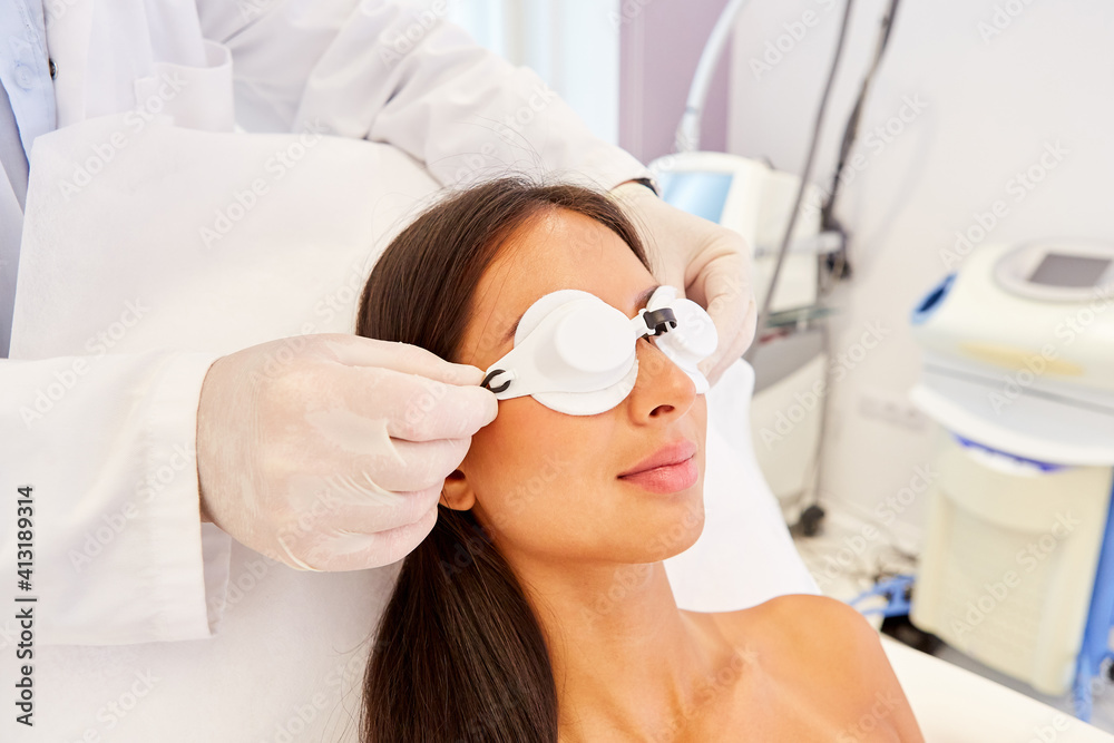 Naklejka premium Woman patient with safety glasses waiting for laser therapy