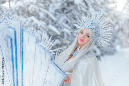 Foto Young girl snow queen in the forest
