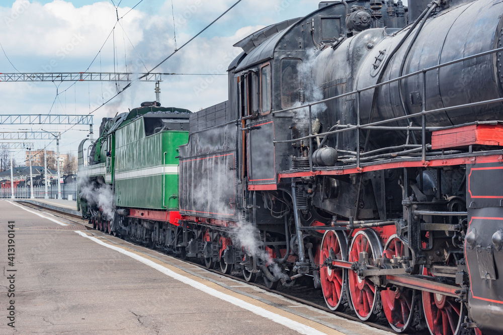Electric and steam trains depart from the station.