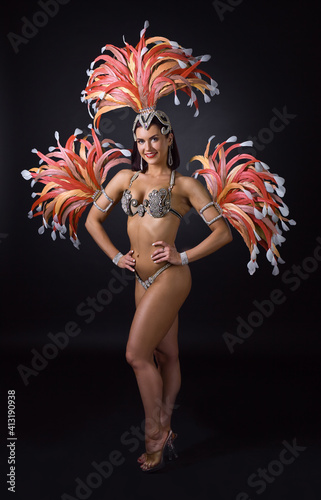 Photos Attractive female cabaret dancer in carnival costume with red and pink feathers
