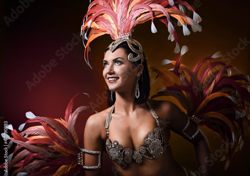 Fototapeta Attractive female cabaret dancer in carnival costume with red and pink feathers
