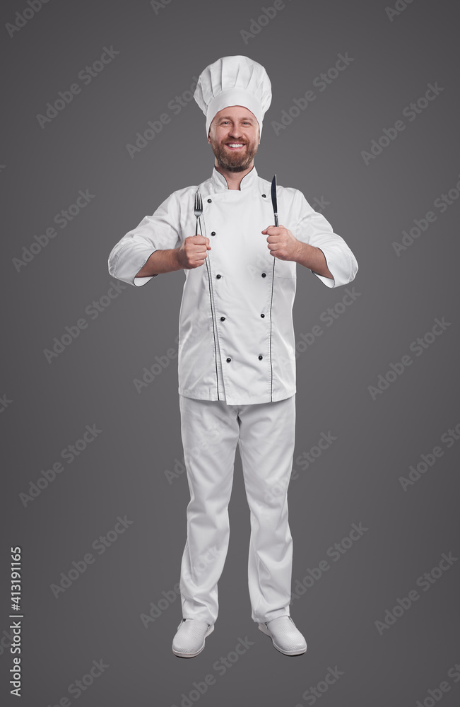 Smiling cook in chef uniform with fork and knife
