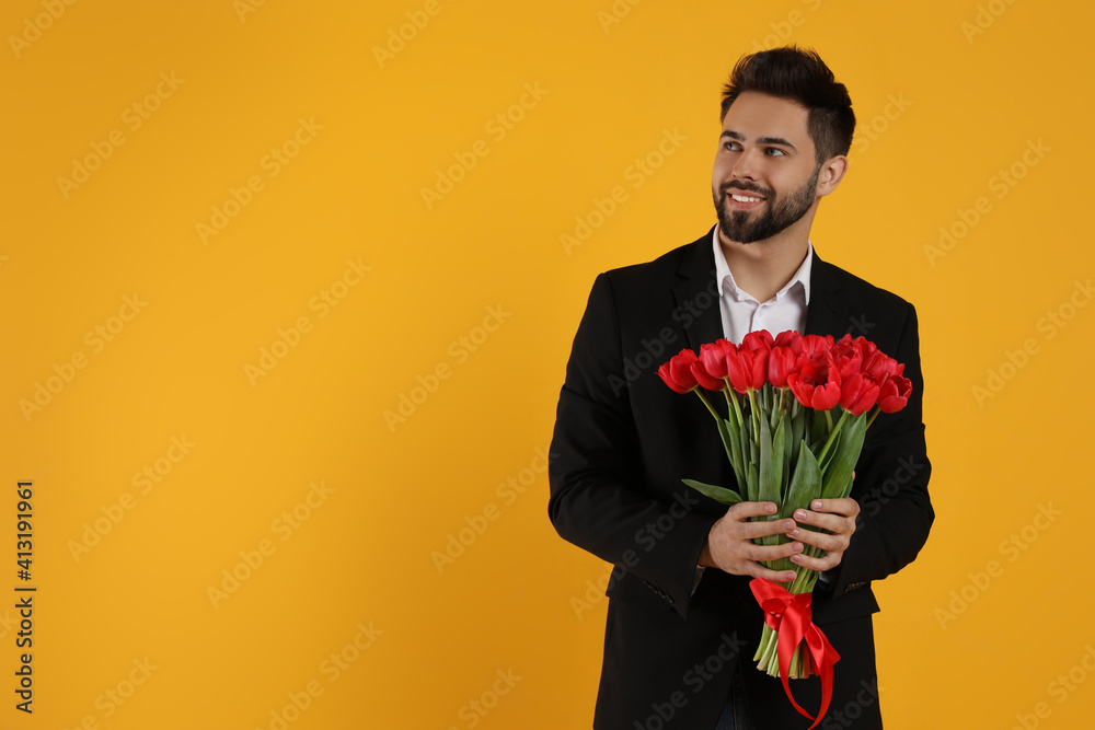 Happy man with red tulip bouquet on yellow background, space for text. 8th of March celebration Happy man with red tulip bouquet on yellow background, space for text. 8th of March celebration