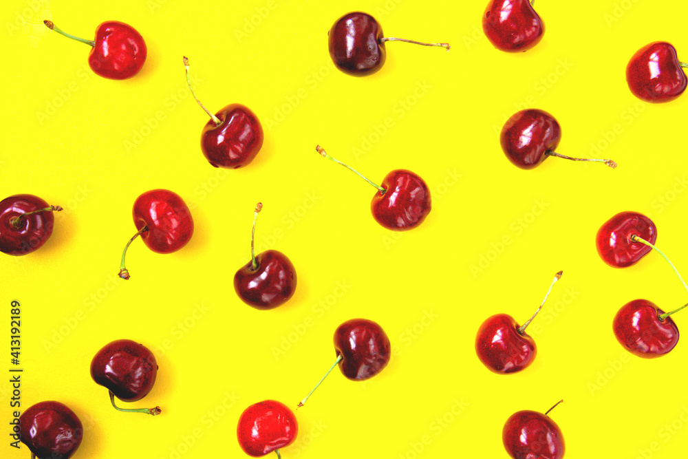 Bright red cherry on bright yellow background. Cherry pattern. Cherries close up. Summer flat lay berry background. Top view Bright red cherry on bright yellow background. Cherry pattern. Cherries close up. Summer flat lay berry background. Top view