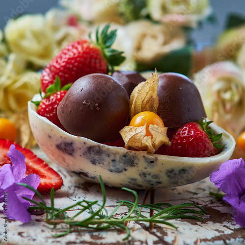 Chocolate egg filled with truffles and strawberries.