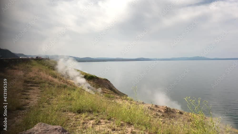 : Steamboat Point overlook with smoke rising from the steam vents along Yellowstone Lake at Yellowstone National Park.