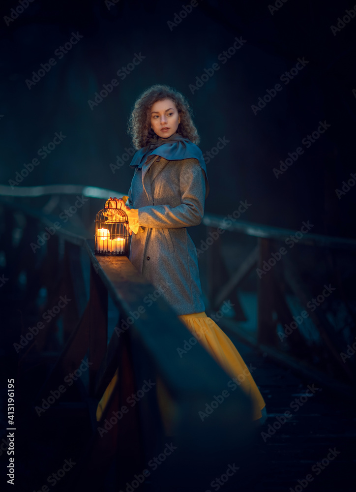 Beautiful girl standing with candles at the bridge in a mystery night naked forest