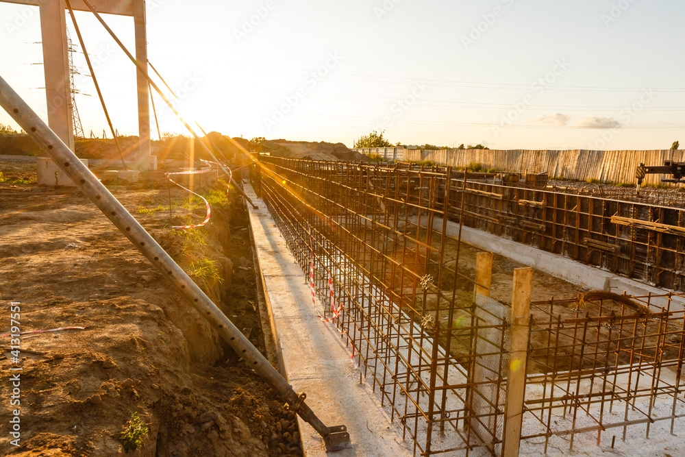Fototapeta premium Design of reinforcement cage of reinforcement for concrete frame house, brick house, formwork for concrete pouring, construction site, working crane, construction of houses