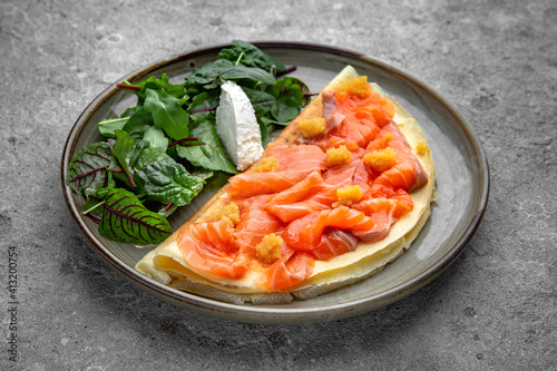 Pancakes with tender fillet of salted salmon with caviar, cheese and herbs. Delicious, hearty, nutritious breakfast. Balanced nutrition for beauty and health.