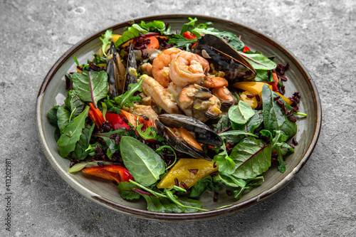 A large portion of seafood salad, vegetables and herbs. Aromatic, nutritious, healthy diet food.