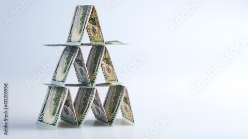 Fotografia ponzi scheme, 100 us dollar bills lined up in house of cards, financial pyramid
