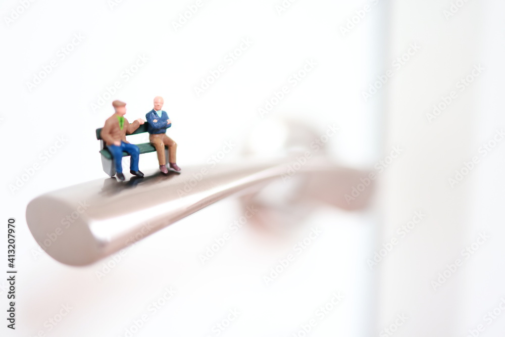 Miniature people on the bench on a hook in the lobby. Retirement, safe life, elder ages. Miniature people on the bench on a hook in the lobby. Retirement, safe life, elder ages.