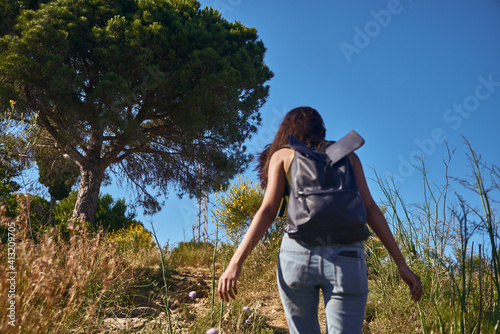 Spirited young lady hiking up a gravel trail © pablocalvog
