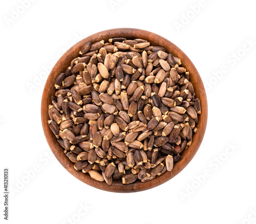 Milk Thistle seed in wooden bowl, isolated on white background. Silybum marianum, Scotch Thistle or Marian Thistle. Top view.