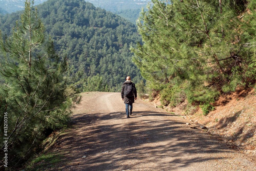 Healthy man walking alone on mountain roads outdoors. To get out of quarantine and be free after the pandemic.