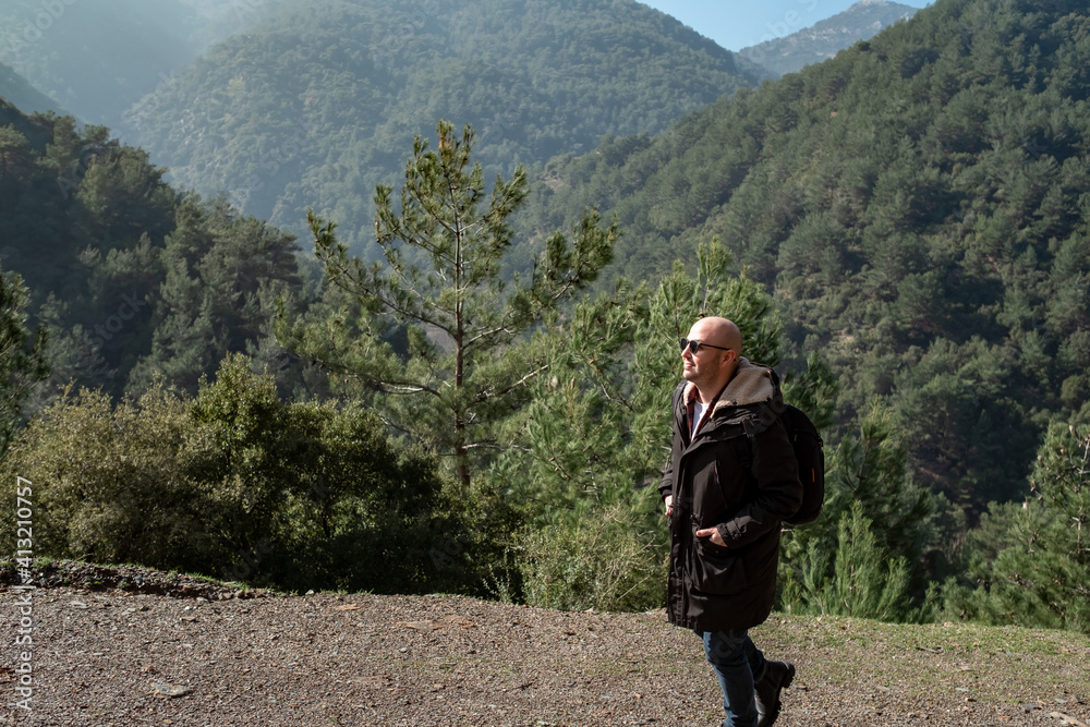 Healthy man walking alone on mountain roads outdoors. To get out of quarantine and be free after the pandemic.