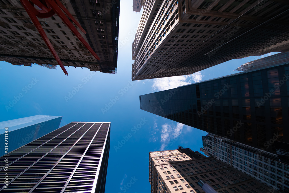 Bottom street view on skyscrapers of New York City with blue sky background. Downtown area, wide angle shot, copy space, place for text