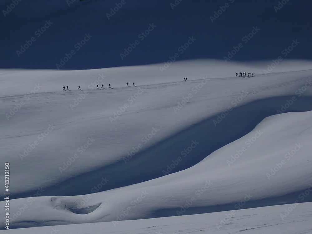 Snow drawings with climbers walking in the distance Snow drawings with climbers walking in the distance