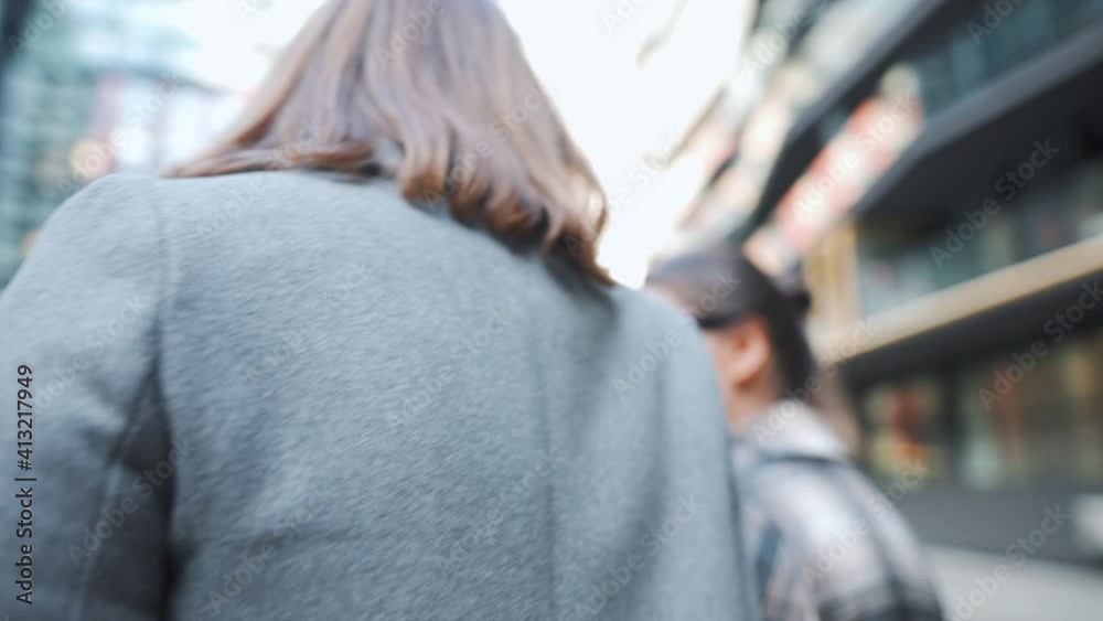 Two happy women walking with takeaway coffee and talking with interest among themselves in the business district. Two happy women walking with takeaway coffee and talking with interest among themselves in the business district.