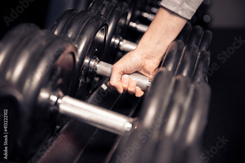 a close-up of hands grabbing a dumbbell