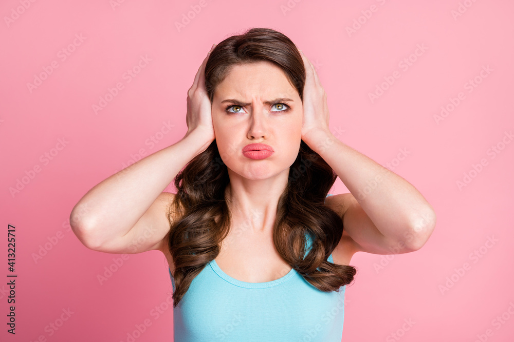 Portrait of stressed upset brunette long hair style girl cover ears pout lips wear blue top isolated on pink color background Portrait of stressed upset brunette long hair style girl cover ears pout lips wear blue top isolated on pink color background