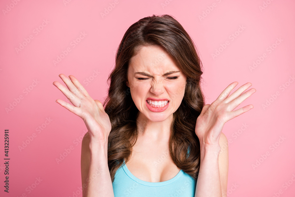 Portrait of angry stressed brunette long hair style girl suffer from pain wear blue top isolated on pink color background Portrait of angry stressed brunette long hair style girl suffer from pain wear blue top isolated on pink color background