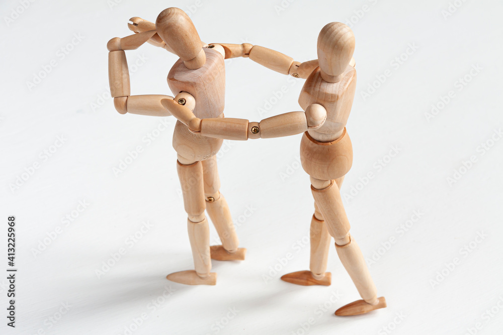 one wooden mannequin comforting another one wooden mannequin comforting another