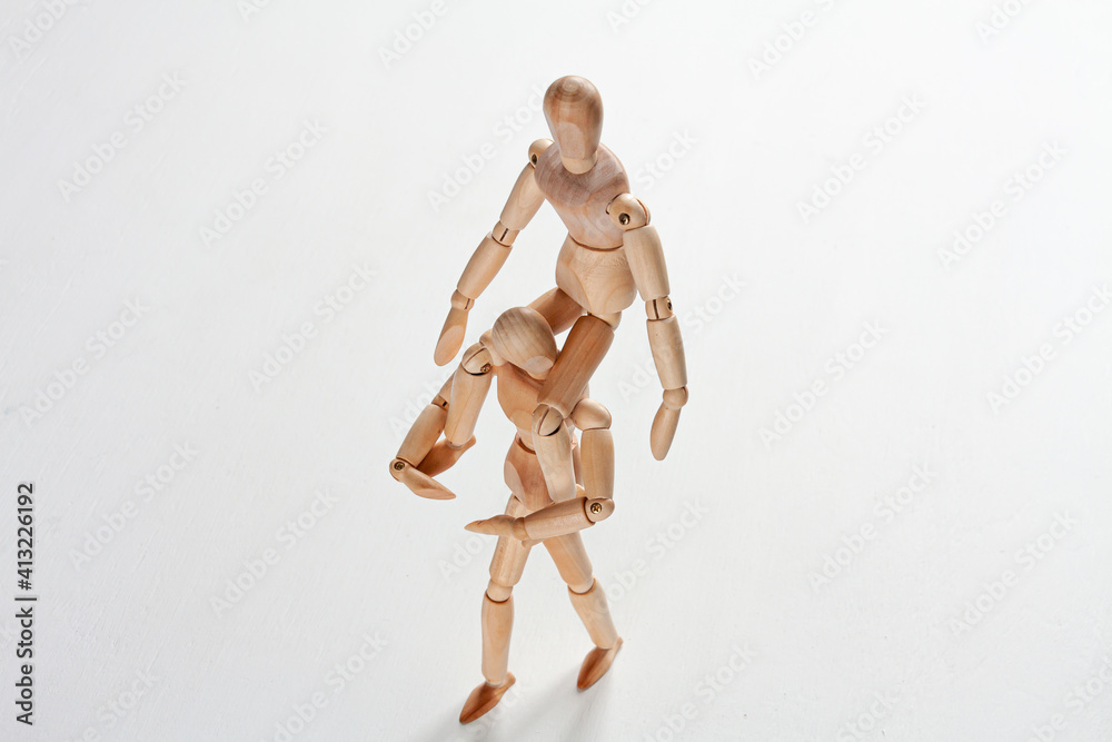 a wooden mannequin sitting on one another mannequin's neck a wooden mannequin sitting on one another mannequin's neck