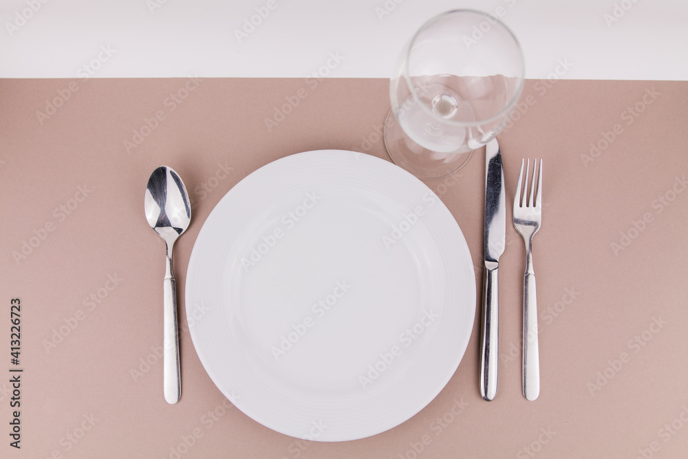 table setting plate fork spoon and knife on gray background white plate table setting plate fork spoon and knife on gray background white plate