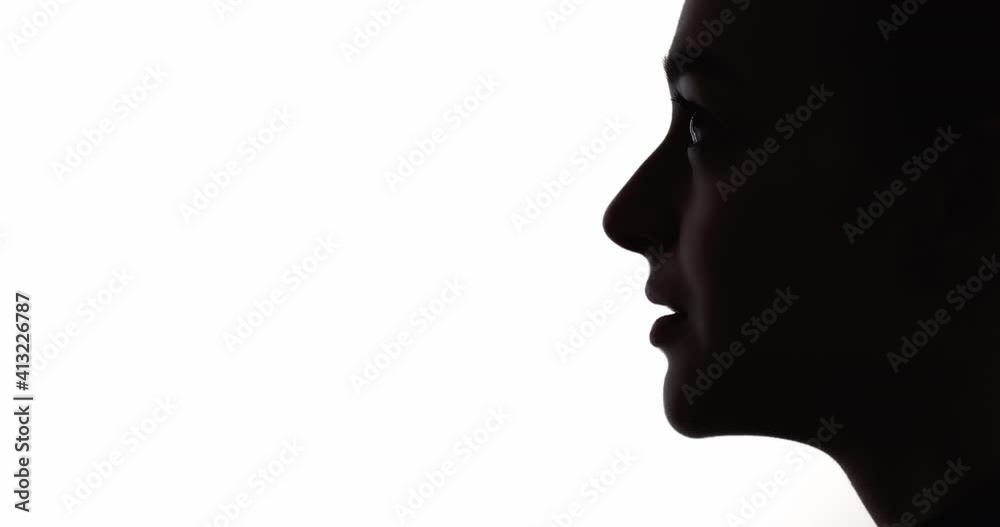 Female silhouette. Future hope. Spiritual freedom. Dream faith. Dark contrast profile face outline of inspired woman looking up praying isolated on white copy space background.