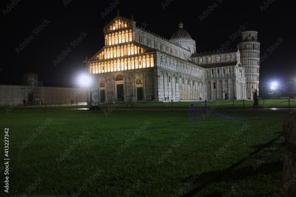 Piazza Miracoli in Pisa seen at night between monuments such as the tower and the solitude of the global pandemic in the dark