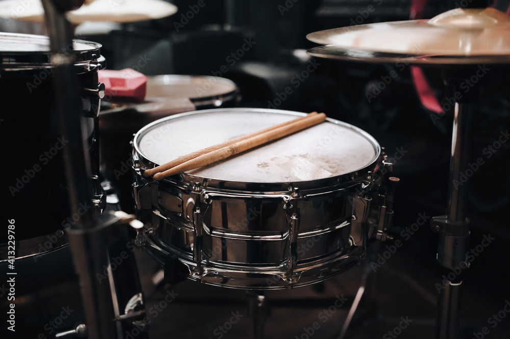 Fototapeta premium Two wooden drumsticks are on the drum kit near the cymbals. The concept of a musician, jazz band and rock band.