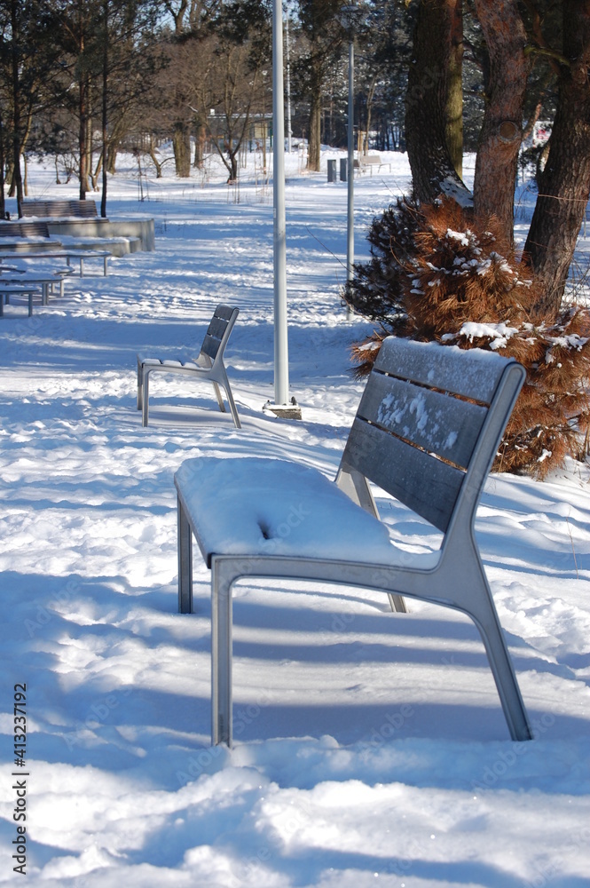 Street furniture, a bench, a winter season park in Europe.