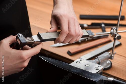 Service man changing a whetstone in a manual sharpener machine