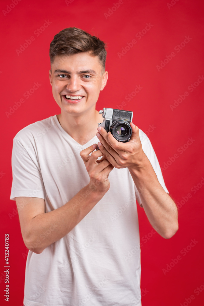Say cheese! Young man take photo with retro dslr camera looking at camera over gray abackground. Portrait of positive man in hat with retro camera standing isolated Say cheese! Young man take photo with retro dslr camera looking at camera over gray abackground. Portrait of positive man in hat with retro camera standing isolated