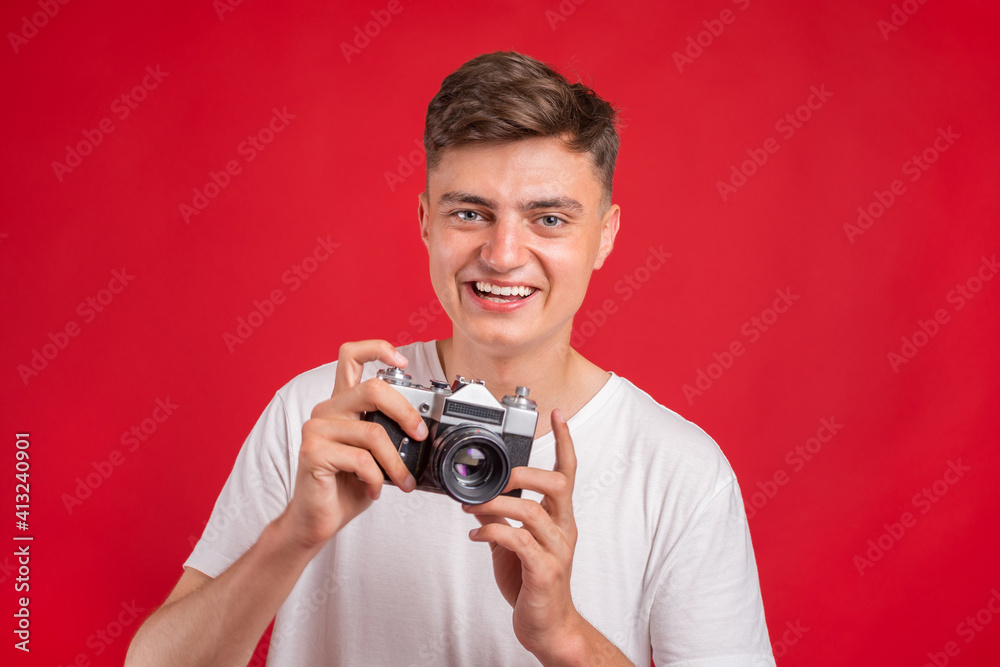 Say cheese! Young man take photo with retro dslr camera looking at camera over gray abackground. Portrait of positive man in hat with retro camera standing isolated Say cheese! Young man take photo with retro dslr camera looking at camera over gray abackground. Portrait of positive man in hat with retro camera standing isolated