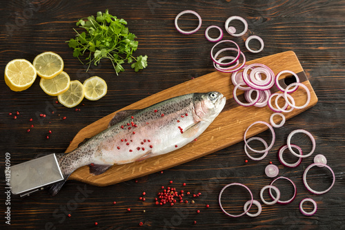 Fresh rainbow trout on a special wooden fish cutting board
