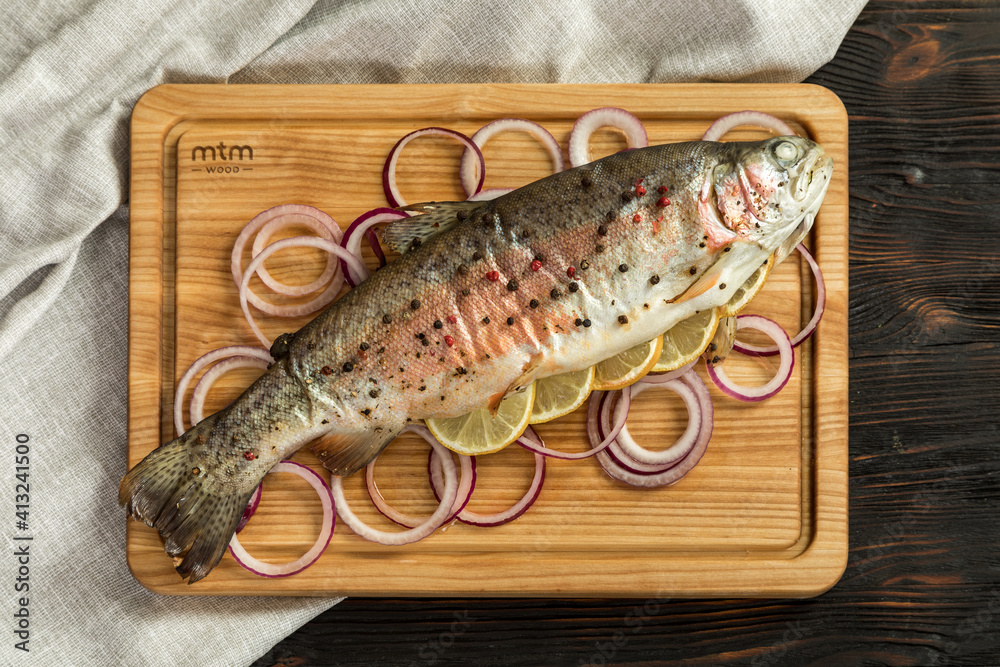 baked rainbow trout on a wooden board for serving