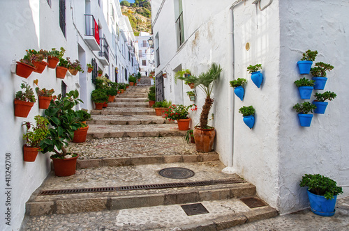 Traditional flowerpots in the street of white village in Andalusia. Pueblos blancos in Spain. Beautiful touristic landmark.