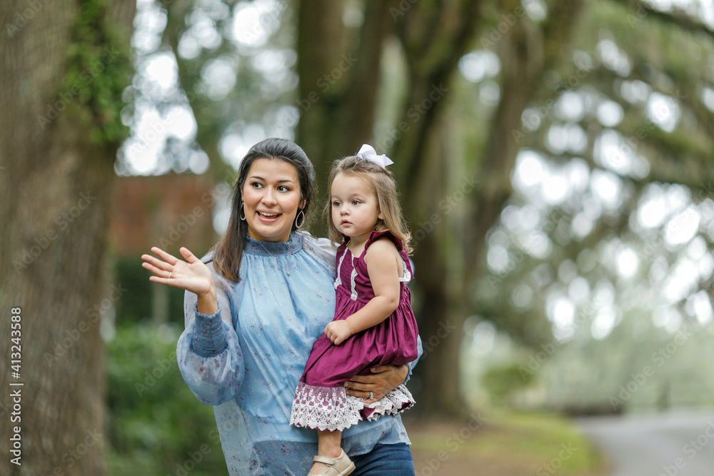 A mother holding her young daughter and explaining something. A mother holding her young daughter and explaining something.